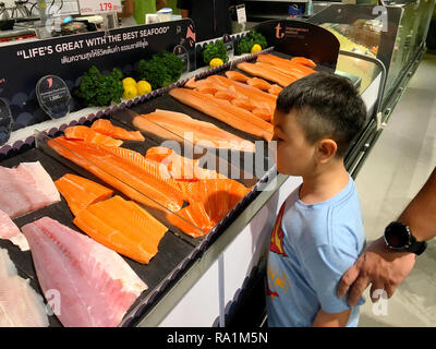 Foto di un ragazzo sta cercando di molti pezzi di salmone crudo pesce per vendere nel supermercato della Tailandia Bangkok, 22 Dicembre 2018 Foto Stock