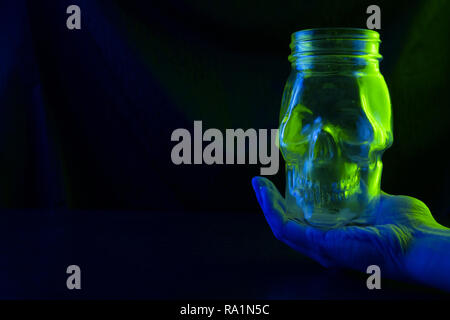 Il veleno immagine concettuale. cranio verde su sfondo scuro Foto Stock