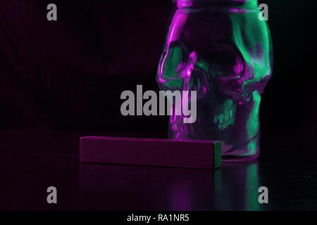 A forma di teschio di vetro in una luce al neon. spazio copia Foto Stock