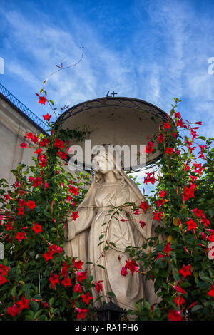 Tranquilla la statua della Madonna con una ghirlanda di fiori presso la chiesa di San Giuseppe e il Convento delle Monache Bernardini nella città vecchia di Cracovia in Polonia Foto Stock