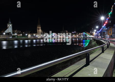 Bella pre Natale passeggiata serale in Inverness, Scotland. Belle le luci di Natale e riverside area al Fiume Ness.Old alta chiesa in backgroud Foto Stock