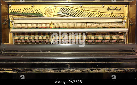 Completare la meccanica di un vecchio Steinbach pianoforte verticale che mostra la piastra con la sintonizzazione i perni di attacco, stringhe, martelli e leve, e chiuso il coperchio della tastiera Foto Stock