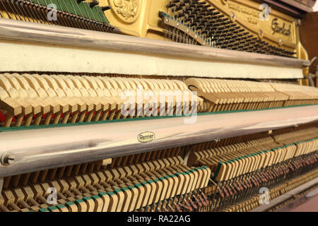 Una vista ravvicinata del meccanico di un pianoforte verticale, con la sintonizzazione i perni di attacco, teste di martello, la vibrante stringhe e la soft mute (sordino) panno di feltro Foto Stock