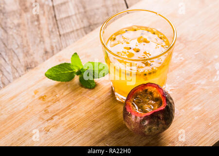 Bicchiere di freschi frutti della passione mint su tavola Foto Stock