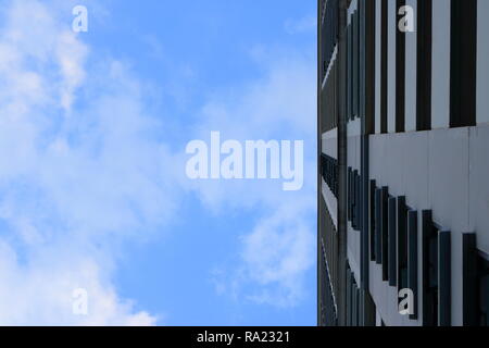 Il cielo blu con nuvole bianche al di sopra di un edificio alto Foto Stock