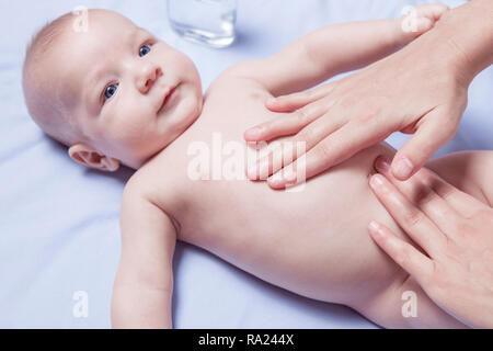 Addome massaggio per 3 mese baby boy. Femmina terapista di massaggio mani Foto Stock