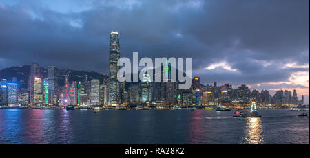 Lo scintillante cielo di Hong Kong si illumina sul Victoria Harbour mentre il sole tramonta su Sai Ying Pun Foto Stock