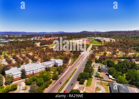 Ampia multi lane Commonwealth Avenue che conduce a Capital Hill e la casa del parlamento nel centro della città di Canberra del Territorio della Capitale Australiana in aer