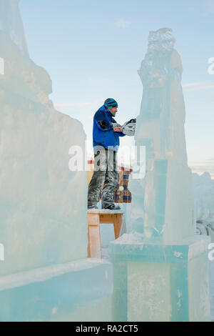 Lo scultore taglia il ghiaccio la figura di Santa Claus per Natale da una motosega ice Foto Stock