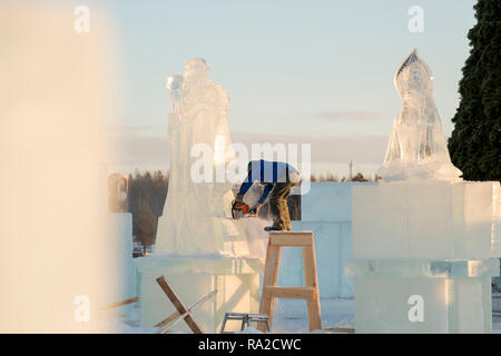 Lo scultore taglia il ghiaccio la figura di Santa Claus per Natale da una motosega ice Foto Stock