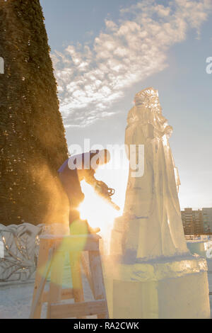 Lo scultore taglia il ghiaccio la figura di Santa Claus per Natale da una motosega ice Foto Stock