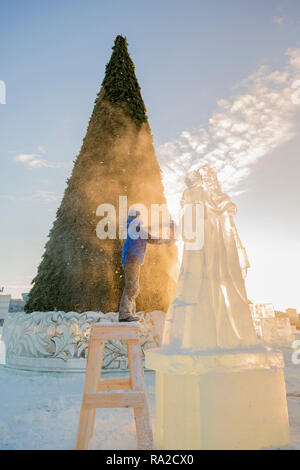 Lo scultore taglia il ghiaccio la figura di Santa Claus per Natale da una motosega ice Foto Stock