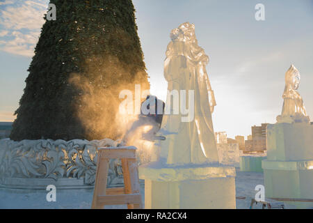 Lo scultore taglia il ghiaccio la figura di Santa Claus per Natale da una motosega ice Foto Stock