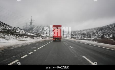 Un lone Royal Mail delivery carrello guida attraverso le Highlands scozzesi in inverno, prima di Natale, su una autostrada A9. Foto Stock