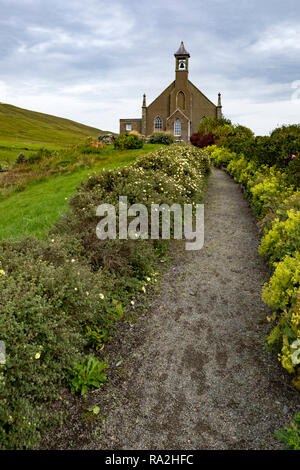 Una chiesa rurale con la torre campanaria e il paesaggio sulla terraferma isola delle Isole Shetland della Scozia in un nuvoloso giorno di estate Foto Stock