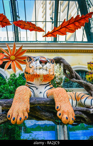 Il raccolto di decorazioni a tema includono una tigre di oziare nella veranda all'interno del Bellagio Hotel and Casino in Las Vegas NV Foto Stock