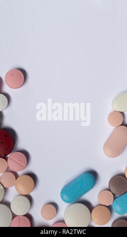 Pillole colorate su sfondo bianco. Legal farmaci per uso umano. Foto Stock
