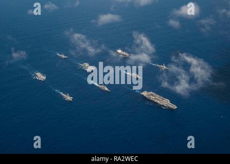 Gli Stati Uniti Navy portaerei USS Ronald Reagan conduce una formazione di Ronald Reagan Strike gruppo, compreso il Ticonderoga-class missile incrociatori USS Antietam, USS Chancellorsville, Arleigh Burke-class guidato-missile cacciatorpediniere USS Benfold e USS Milius durante l'esercizio Valiant scudo 2018 Settembre 17, 2018 nel Mare delle Filippine. Foto Stock