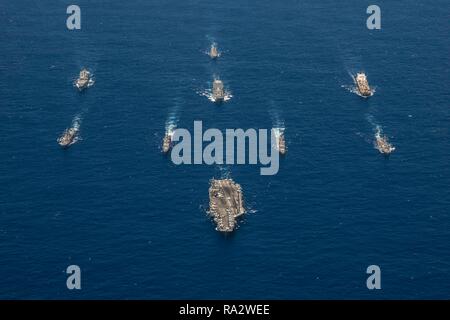 Gli Stati Uniti Navy portaerei USS Ronald Reagan conduce una formazione di Ronald Reagan Strike gruppo, compreso il Ticonderoga-class missile incrociatori USS Antietam, USS Chancellorsville, Arleigh Burke-class guidato-missile cacciatorpediniere USS Benfold e USS Milius durante l'esercizio Valiant scudo 2018 Settembre 17, 2018 nel Mare delle Filippine. Foto Stock