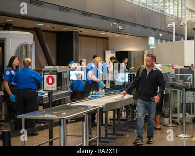 L'uomo passa attraverso Transportation Security Administration TSA di punto di controllo di sicurezza in aeroporto Internazionale Seattle-Tacoma Foto Stock