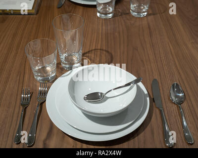 Set da pranzo con utensili, ciotole e piatti con sopra la testa la luce Foto Stock