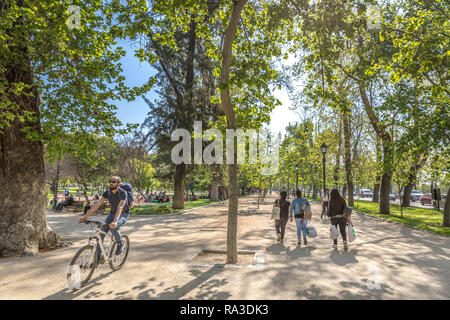 Santiago del Cile - 1° OTT 2017 - Un ragazzo in una bicicletta e un gruppo di persone che camminano in un open air parco pubblico di Santiago del Cile, capitale del Cile Foto Stock