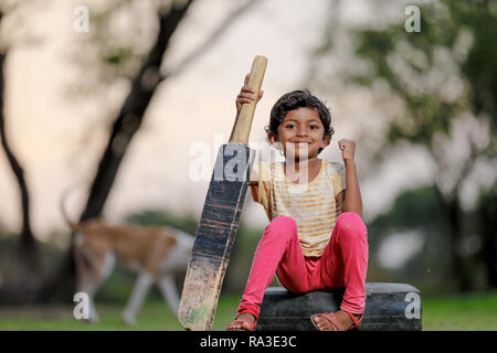 Ragazza indiana bambino giocare a cricket Foto Stock