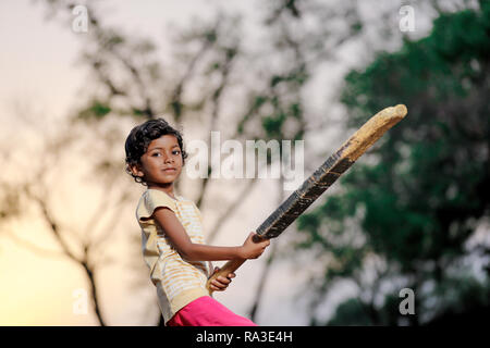 Ragazza indiana bambino giocare a cricket Foto Stock