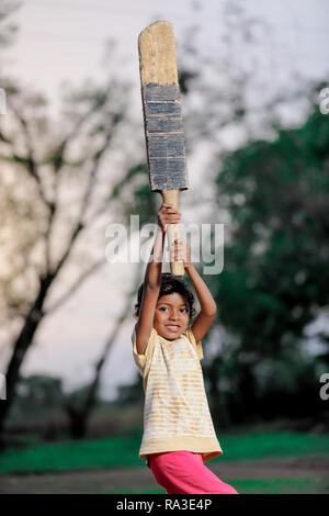 Ragazza indiana bambino giocare a cricket Foto Stock