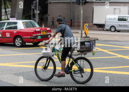 Un pilota di consegna con il suo pranzo scatole in Hennessy Road Hong Kong Foto Stock