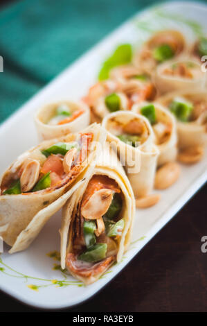 Sushi-Style involtini di pollo con salsiccia per pizza, verdura e noci. Spuntini salutari. Foto Stock