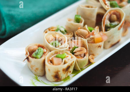 Sushi-Style involtini di pollo con salsiccia per pizza, verdura e noci. Spuntini salutari. Foto Stock