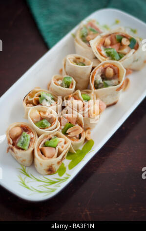 Sushi-Style involtini di pollo con salsiccia per pizza, verdura e noci. Spuntini salutari. Foto Stock