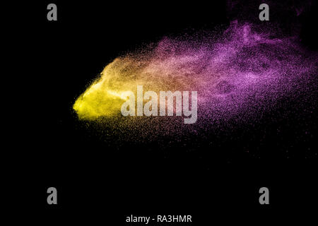 Multi colore Esplosione particelle su sfondo nero. La polvere colorata splatter su sfondo scuro. Foto Stock