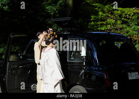 Lo Shintoismo sposa che indossa il tradizionale abito bianco Preparazione per andare in macchina a Meiji Jingu sacrario scintoista Foto Stock