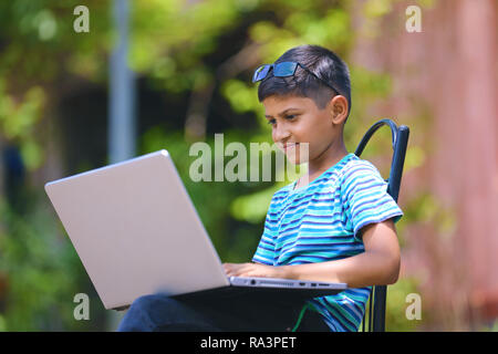Bambino lavorando sul computer portatile Foto Stock
