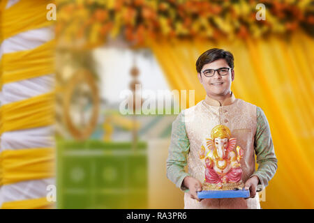 Giovane uomo indiano con Lord Ganesha , celebrando Ganesh festival Foto Stock