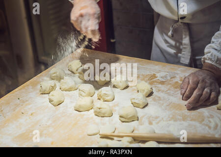 Lo chef cinese rendendo gnocchi di patate in cucina Foto Stock