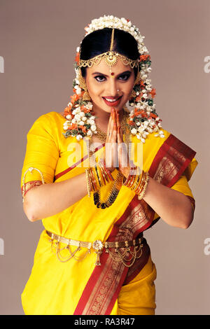 Un ritratto di un sud indiane sposa vestito in costume tradizionale, saluto con le mani incrociate (NAMASTE) Foto Stock