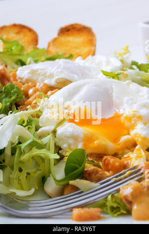 Classica insalata francese, grande insalata Lyonnaise. Il piatto con il verde delle foglie di lattuga, Digione la salsa di senape con pezzi di pancetta fritta e grigliate di pane francese, Foto Stock