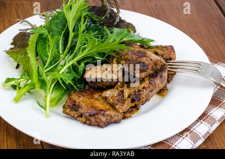 Fettine di fegato, foglie verdi di insalate. Foto Studio Foto Stock