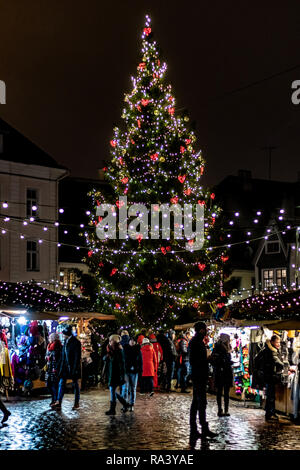 Albero di Natale decorato completamente nella zona centrale di piazza della città vecchia con la gente che camminava nel mercato Foto Stock