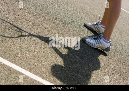 Close up di una femmina di holding racchetta da tennis Racchetta o su una luminosa giornata di sole Foto Stock