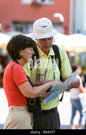 Maturo coppia turisti della città che studiano la mappa stradale. Raekoja Plats (piazza del Municipio)...al centro della città vecchia di Tallinn. Estonia. Foto Stock