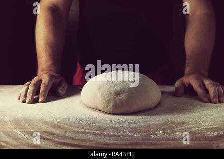 Capo dei panettieri preparare la pasta per pane in una panetteria. Cucina professionale. Foto Stock