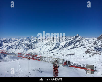 Gru da cantiere sulla sommità del Klein Matterhorn mountain con Swiss e alpi italiane in background Foto Stock