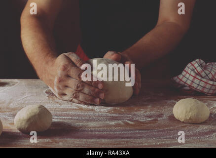 Capo dei panettieri preparare la pasta per pane in una panetteria. Cucina professionale. Foto Stock