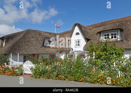 Con tetto di paglia casa con fiori estivi, Nebel, Amrum, Frisia settentrionale, Schleswig-Holstein, Germania Foto Stock