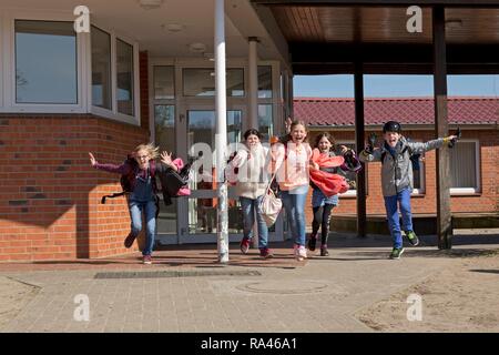 Gli studenti dopo la scuola, inizio di vacacions, in esecuzione al di fuori della scuola, scuola primaria, Bassa Sassonia, Germania Foto Stock