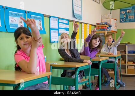 Gli studenti alzando la mano in aula, scuola elementare, Bassa Sassonia, Germania Foto Stock